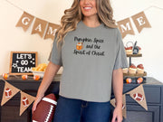 Grey pumpkin spice Christian t-shirt worn by a woman, featuring the phrase 'Pumpkin Spice and the Spirit of Christ'.
