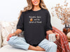 Woman wearing a black Pumpkin Spice Christian t-shirt, holding a coffee mug, celebrating autumn and faith.
