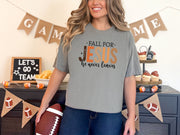 Fall for Jesus graphic tee in grey worn by model with football and autumn decor in background.