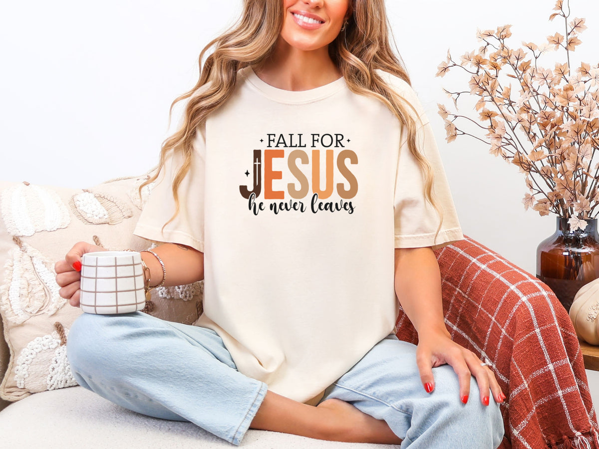 Model sitting with coffee, wearing Fall for Jesus graphic tee in ivory, celebrating faith and autumn.