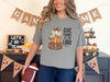 Woman wearing a grey Give Thanks to the Lord t-shirt with pumpkin design, celebrating gratitude and faith.