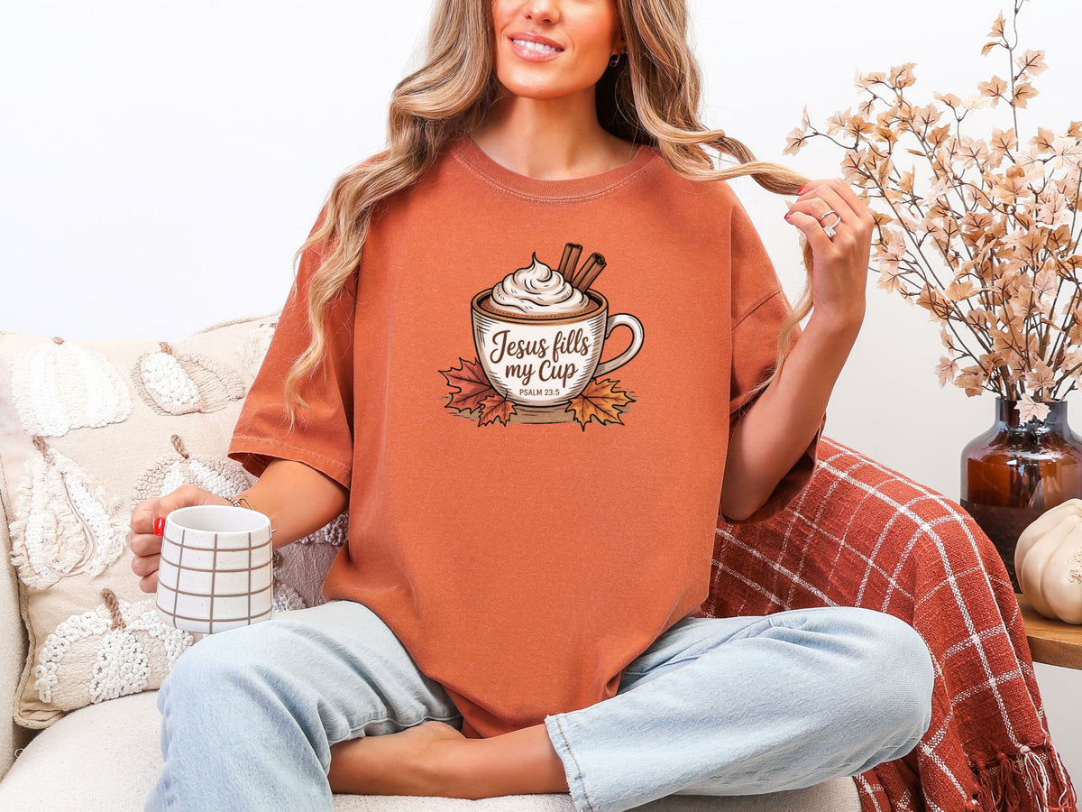 Model in yam Jesus Fills My Cup t-shirt holding a coffee mug, showcasing an uplifting Christian graphic tee.