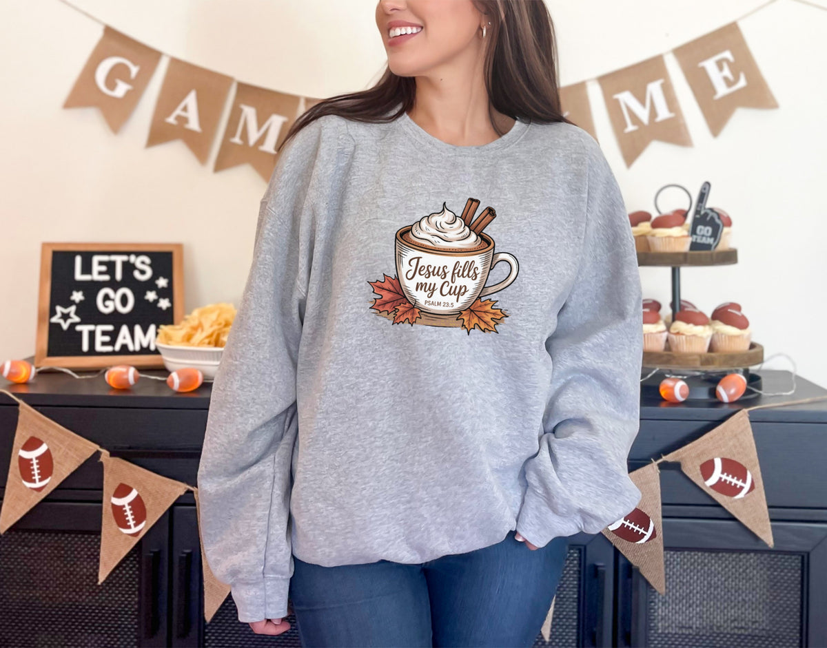 Christian sweatshirt with faith message featuring Jesus Fills My Cup graphic, worn by a smiling woman in sport grey.