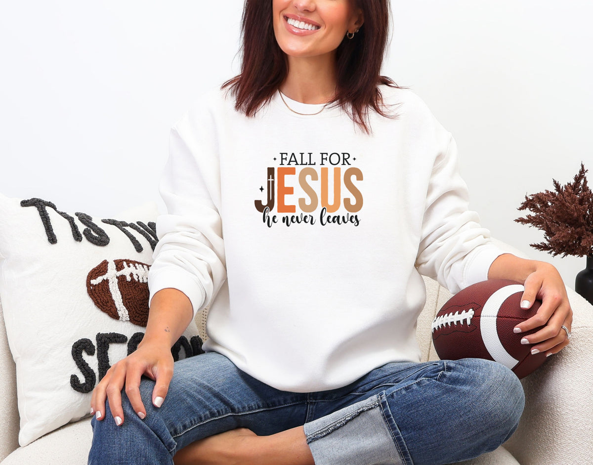 Woman wearing a white Christian fall sweatshirt with 'Fall for Jesus He Never Leaves' design, cozy autumn vibe.