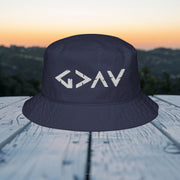 God Is Greater Than Highs and Lows Bucket Hat displayed on a wooden table with a scenic background.