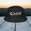 God Is Greater Than Highs and Lows Bucket Hat on a wooden surface with a scenic background.