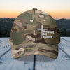 Man of God Dad Husband Embroidered Flexfit Hat in camouflage design with cross on outdoor wooden surface.